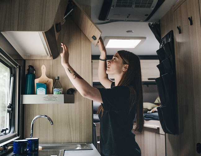 Femme qui range des equipements de cuisine