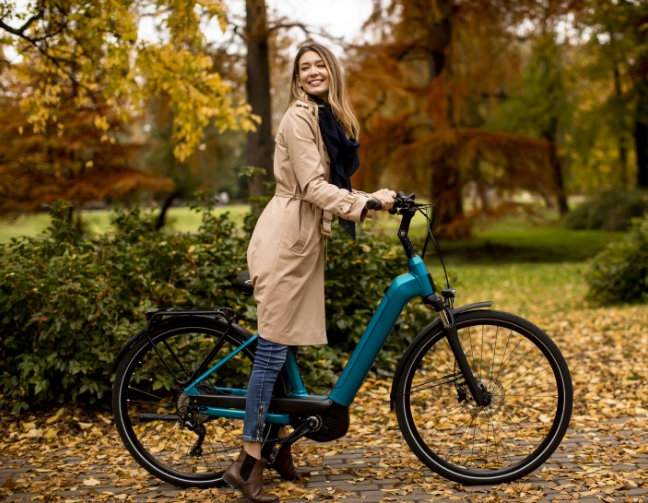 Femme sur un vélo dans un parc en automne